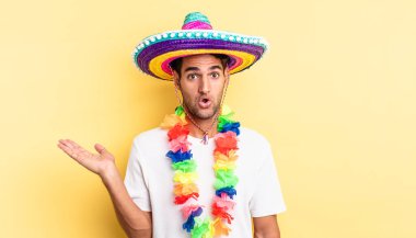 İspanyol yakışıklı adam şaşırmış ve şok olmuş görünüyor. Çenesi düşmüş ve elinde bir nesne var. Meksika partisi konsepti