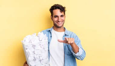 İspanyol yakışıklı adam kamerayı göstererek seni seçiyor. kağıt toplar çöp konsepti