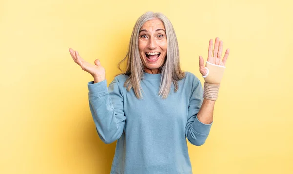 中年の可愛い女は何か信じられないほどの幸せと驚きを感じる 手の包帯の概念 — ストック写真