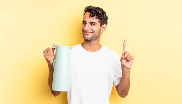 ヒスパニック系のハンサムな男は笑顔と友好的に見える ナンバーワンを示しています コーヒー魔法瓶のコンセプト — ストック写真