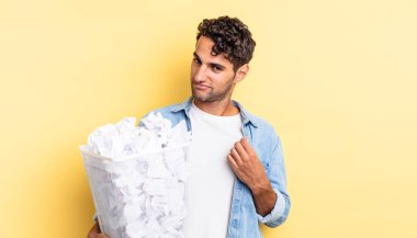 İspanyol yakışıklı adam kibirli, başarılı, pozitif ve gururlu görünüyor. kağıt toplar çöp konsepti