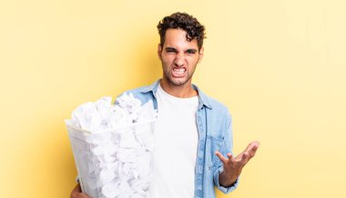 İspanyol yakışıklı adam sinirli, sinirli ve sinirli görünüyor. kağıt toplar çöp konsepti