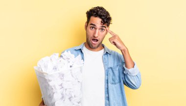 İspanyol yakışıklı adam şaşırmış görünüyor, yeni bir düşünce, fikir ya da konsept fark ediyor. kağıt toplar çöp konsepti