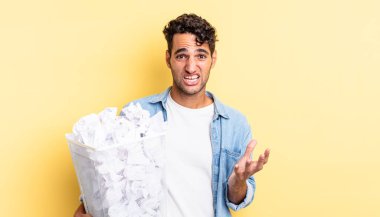 İspanyol yakışıklı adam umutsuz, sinirli ve stresli görünüyor. kağıt toplar çöp konsepti