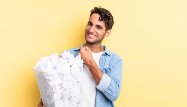 İspanyol yakışıklı adam kendini mutlu hissediyor ve bir meydan okumayla yüzleşiyor ya da kutluyor. kağıt toplar çöp konsepti