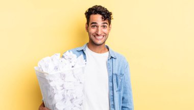 İspanyol yakışıklı adam mutlu ve hoş bir şekilde şaşırmış görünüyor. kağıt toplar çöp konsepti