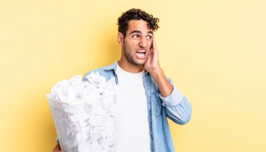İspanyol yakışıklı adam mutlu, heyecanlı ve şaşırmış hissediyor. kağıt toplar çöp konsepti