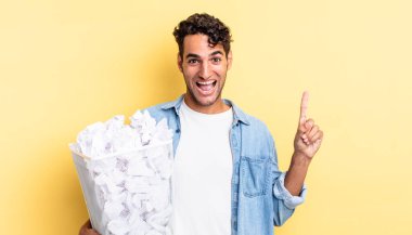 İspanyol yakışıklı bir adam bir fikri fark ettikten sonra mutlu ve heyecanlı bir dahi gibi hissediyor. kağıt toplar çöp konsepti
