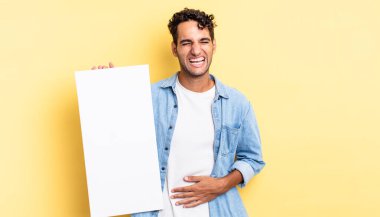 İspanyol yakışıklı bir adam komik bir şakaya yüksek sesle gülüyor. boş tuval kavramı