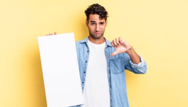 Latin asıllı yakışıklı adam kızgın, baş parmağını kaldırıyor. boş tuval kavramı