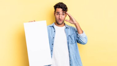 İspanyol yakışıklı adam mutlu, şaşkın ve şaşırmış görünüyor. boş tuval kavramı