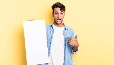 İspanyol yakışıklı adam mutlu hissediyor ve heyecanla kendini işaret ediyor. boş tuval kavramı