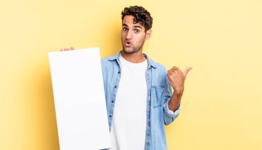 İspanyol yakışıklı adam, inançsızlıktan şaşkın şaşkın bakıyor. boş tuval kavramı