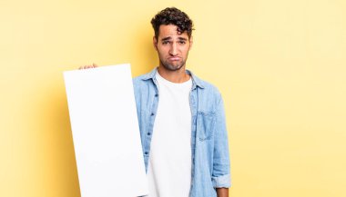 Hispanik yakışıklı adam üzgün ve mızmız, mutsuz bir bakışla ağlıyor. boş tuval kavramı