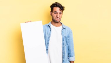 İspanyol yakışıklı adam kafası karışmış ve şaşkın görünüyor. boş tuval kavramı