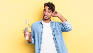 İspanyol yakışıklı adam kendini stresli, endişeli ya da korkmuş hissediyor, elleri başının üstünde. su şişesi kavramı