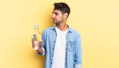 Profil görünümlü İspanyol yakışıklı adam hayal mi kuruyor, hayal mi kuruyor, hayal mi kuruyor? su şişesi kavramı