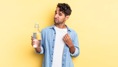 İspanyol yakışıklı adam kibirli, başarılı, pozitif ve gururlu görünüyor. su şişesi kavramı