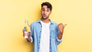 İspanyol yakışıklı adam, inançsızlıktan şaşkın şaşkın bakıyor. su şişesi kavramı