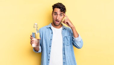 İspanyol yakışıklı adam şaşırmış görünüyor, yeni bir düşünce, fikir ya da konsept fark ediyor. su şişesi kavramı