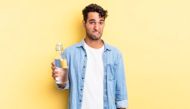 İspanyol yakışıklı adam kafası karışmış ve şaşkın görünüyor. su şişesi kavramı