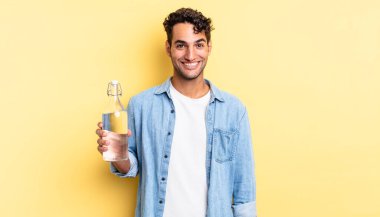 İspanyol yakışıklı adam mutlu ve hoş bir şekilde şaşırmış görünüyor. su şişesi kavramı