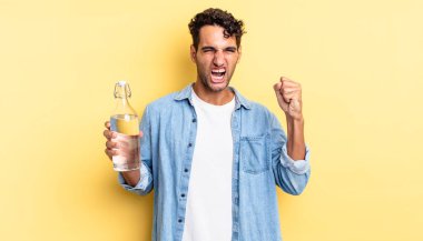 İspanyol yakışıklı adam sinirli bir ifadeyle agresif bir şekilde bağırıyor. su şişesi kavramı