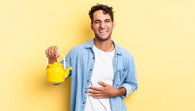 İspanyol yakışıklı bir adam komik bir şakaya yüksek sesle gülüyor. çaydanlık konsepti