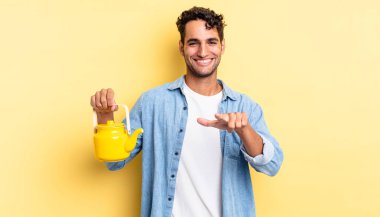 İspanyol yakışıklı adam kamerayı göstererek seni seçiyor. çaydanlık konsepti