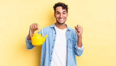 İspanyol yakışıklı adam şokta, gülüyor ve başarıyı kutluyor. çaydanlık konsepti