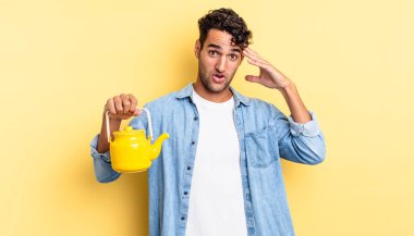 İspanyol yakışıklı adam mutlu, şaşkın ve şaşırmış görünüyor. çaydanlık konsepti