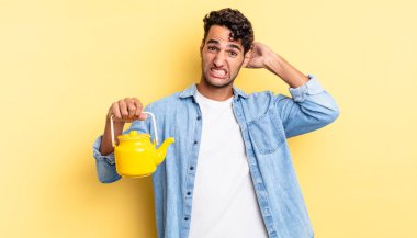 İspanyol yakışıklı adam kendini stresli, endişeli ya da korkmuş hissediyor, elleri başının üstünde. çaydanlık konsepti