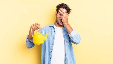 İspanyol yakışıklı adam şok olmuş, korkmuş ya da korkmuş görünüyor. Yüzü elle kapatılmış. çaydanlık konsepti