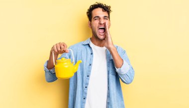 İspanyol yakışıklı adam kendini mutlu hissediyor, elleri ağızının yanında bağırıyor. çaydanlık konsepti