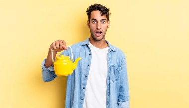 İspanyol yakışıklı adam çok şaşırmış ya da şaşkın görünüyor. çaydanlık konsepti