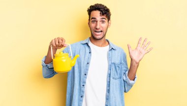 İspanyol yakışıklı adam kendini mutlu hissediyor ve inanılmaz bir şeye hayret ediyor. çaydanlık konsepti