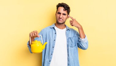 İspanyol yakışıklı adam kafası karışık ve şaşkın hissediyor, senin deli olduğunu gösteriyor. çaydanlık konsepti