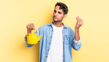 İspanyol yakışıklı adam kapiş ya da para hareketi yapıyor, sana ödemeni söylüyor. çaydanlık konsepti