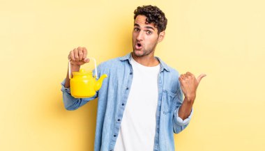 İspanyol yakışıklı adam, inançsızlıktan şaşkın şaşkın bakıyor. çaydanlık konsepti