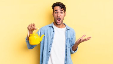 İspanyol yakışıklı adam inanılmaz bir sürprizle şaşkına dönmüş ve hayrete düşmüştü. çaydanlık konsepti