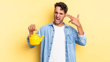 İspanyol yakışıklı adam mutsuz ve stresli görünüyor, intihar jesti silah işareti yapıyor. çaydanlık konsepti