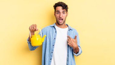 İspanyol yakışıklı adam şok olmuş ve ağzı açık, kendini işaret ederek şaşırmış görünüyor. çaydanlık konsepti