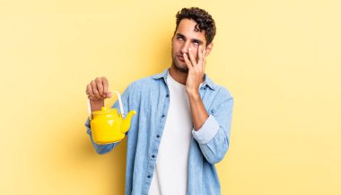 İspanyol yakışıklı bir adam yorgun, bıkkın ve uykulu hissediyor. çaydanlık konsepti