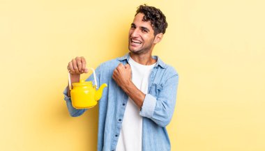 İspanyol yakışıklı adam kendini mutlu hissediyor ve bir meydan okumayla yüzleşiyor ya da kutluyor. çaydanlık konsepti