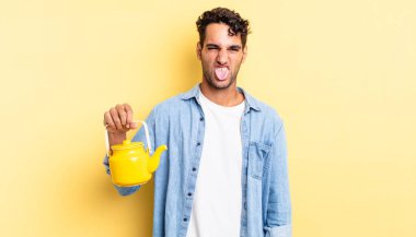 İspanyol yakışıklı adam iğreniyor, sinirleniyor ve dili dışarı çıkıyor. çaydanlık konsepti