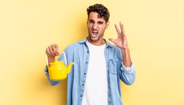 İspanyol yakışıklı adam ellerini havaya kaldırarak bağırıyor. çaydanlık konsepti