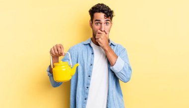 İspanyol yakışıklı adam şok olmuş bir şekilde ağzını kapatıyor. çaydanlık konsepti