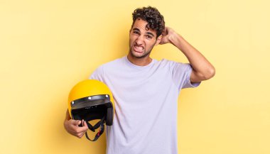 İspanyol yakışıklı adam kendini stresli, endişeli ya da korkmuş hissediyor, elleri başının üstünde. Motosiklet kaskı konsepti