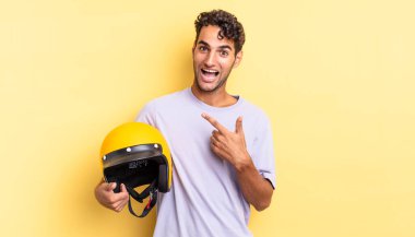 İspanyol yakışıklı adam heyecanlı ve şaşırmış görünüyor. Motosiklet kaskı konsepti