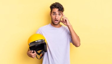 İspanyol yakışıklı adam şaşırmış görünüyor, yeni bir düşünce, fikir ya da konsept fark ediyor. Motosiklet kaskı konsepti